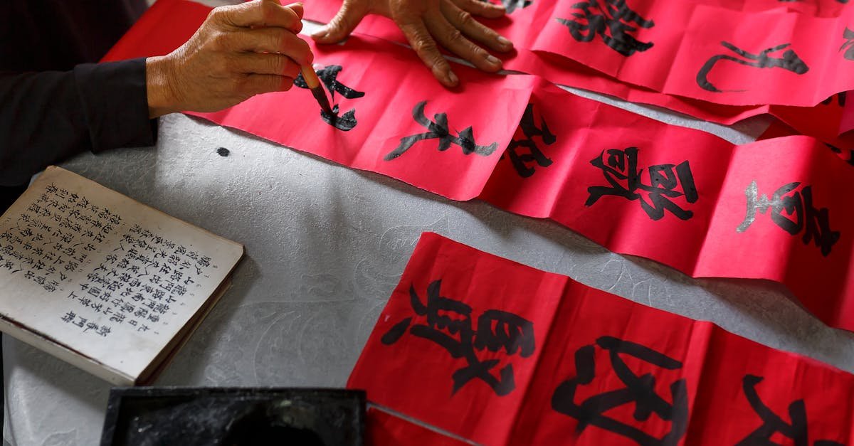 Artist creating traditional Chinese calligraphy on red paper for cultural celebration.